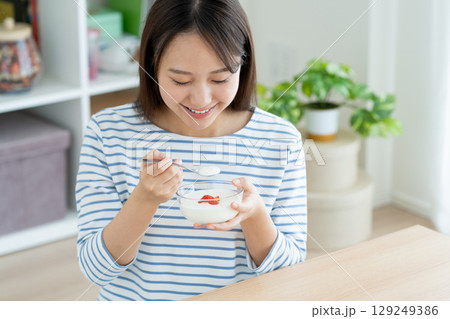 ヨーグルトを食べる若い女性 129249386