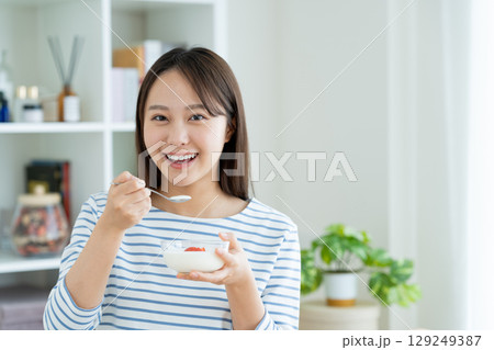 ヨーグルトを食べる若い女性 129249387