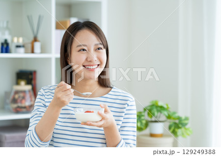 ヨーグルトを食べる若い女性 129249388