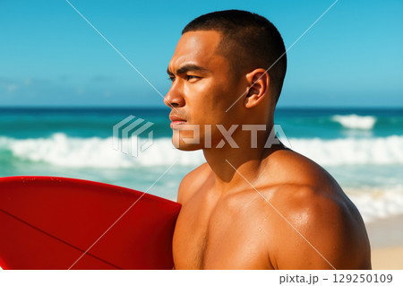Confident young man with short hair holding red surfboard on sunny sandy beach, gazing towards ocean waves under clear blue sky, AI Generative 129250109