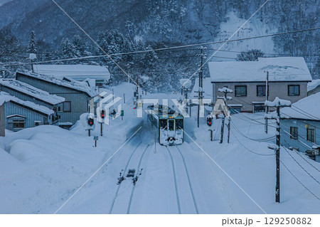 雪の中を走る列車と静かな駅風景 129250882