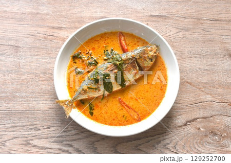spicy boiled mackerel topping chop lemon grass in red curry sauce on plate  129252700