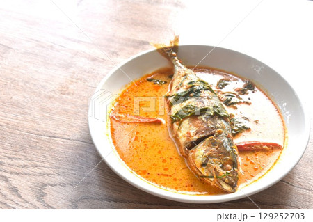 spicy boiled mackerel topping chop lemon grass in red curry sauce on plate  129252703