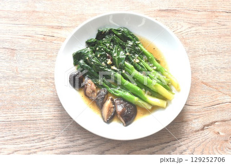 fried Kailaan Chinese kale and black mushroom dressing oyster sauce with chop garlic on plate 129252706