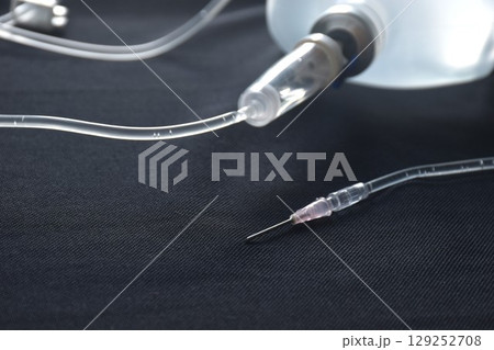 needle for saline solution and rubber tube arranging on black background 129252708