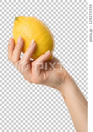 Hand presenting bright yellow lemon isolated on transparent background, sour citrus ingredient 129253359