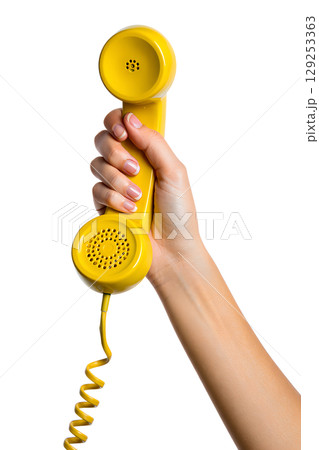 Hand holding vintage yellow rotary phone receiver, retro communication device isolated on transparent background Hand holding vintage yellow rotary phone receiver, retro communication device isolated on transparent background 129253363