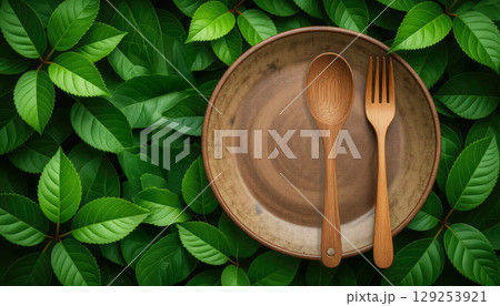 Fresh green natural background with wooden spoon, fork and plate. Natural textures concept Fresh green natural background with wooden spoon, fork and plate. Natural textures concept 129253921