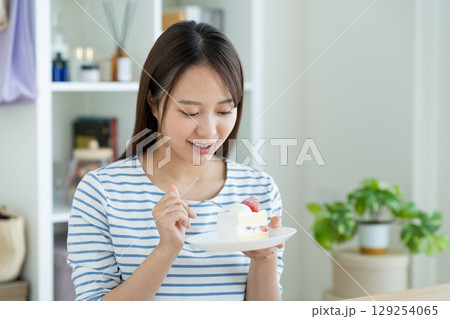 ケーキを食べる若い女性 129254065
