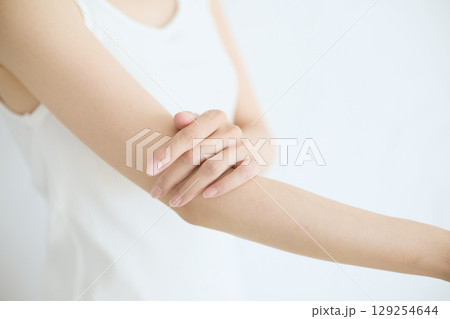 肌に触れてスキンケアする若い女性の笑顔 – 129254644