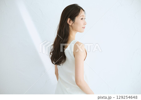 肌に触れてスキンケアする若い女性の笑顔 – 129254648