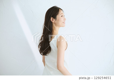 肌に触れてスキンケアする若い女性の笑顔 – 129254651