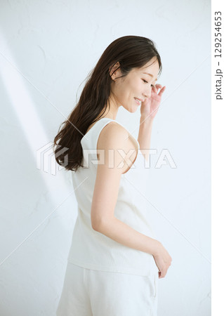 肌に触れてスキンケアする若い女性の笑顔 – 129254653