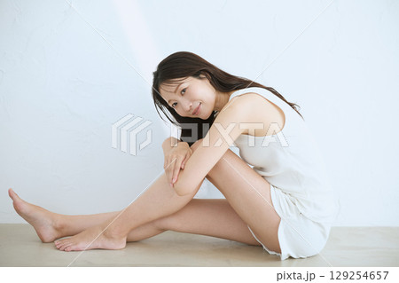 肌に触れてスキンケアする若い女性の笑顔 – 129254657