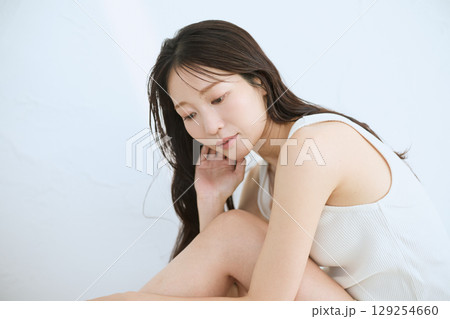 肌に触れてスキンケアする若い女性の笑顔 – 129254660