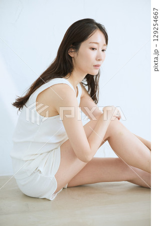 肌に触れてスキンケアする若い女性の笑顔 – 129254667