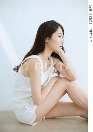 肌に触れてスキンケアする若い女性の笑顔 – 129254670