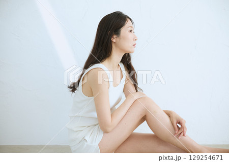 肌に触れてスキンケアする若い女性の笑顔 – 129254671