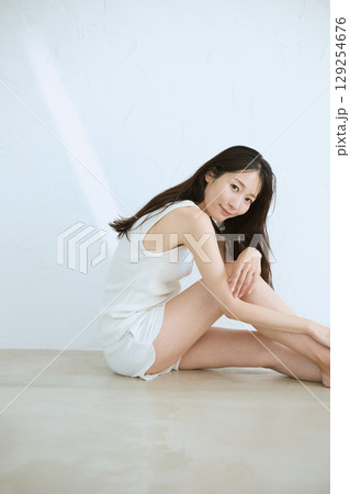 肌に触れてスキンケアする若い女性の笑顔 – 129254676