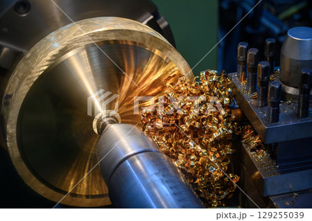 Close up scene the lathe machine finish cut the brass material parts and the pile of scrap chips. 129255039