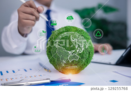 ESG Sustainability concept in office, carbon footprint, recycle, and renewable energy icons. Businessman holding green moss globe with net zero. ESG Sustainability concept in office, carbon footprint, recycle, and renewable energy icons. Businessman holding green moss globe with net zero. 129255768