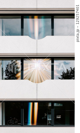 Modern apartment building with glass facade and light reflection patterns Modern apartment building with glass facade and light reflection patterns 129257401