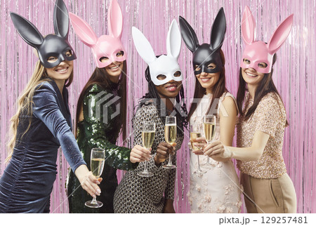 Joyful women in bunny masks with champagne glasses celebrating during carnival or bachelorette party Joyful women in bunny masks with champagne glasses celebrating during carnival or bachelorette party 129257481