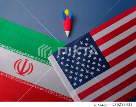Top view rocket between us america and iran flag on a blue background. Geopoilitic concept.. 129258432