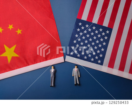 China and us america flag with miniature people on a blue background. China and us america flag with miniature people on a blue background. 129258433