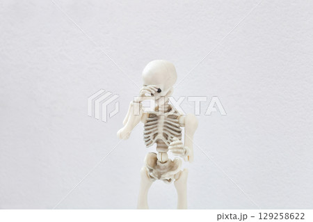 Human skeleton covers his face with his hand, shy and shame concept Human skeleton covers his face with his hand, shy and shame concept 129258622