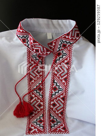 Ukrainian national embroidery vyshyvanka. White traditional ukrainian clothing with embroidery patterns on a collar Ukrainian national embroidery vyshyvanka. White traditional ukrainian clothing with embroidery patterns on a collar 129259387