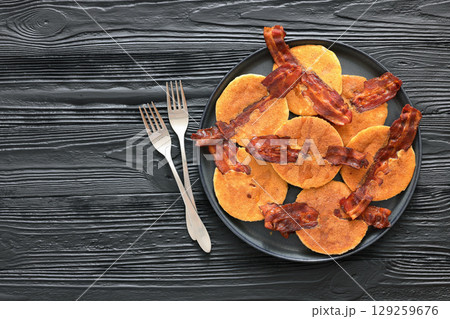bacon pancakes drizzled with sirup on a plate bacon pancakes drizzled with sirup on a plate 129259676