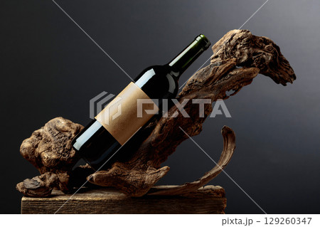Bottle of red wine with empty label on a old snags. Bottle of red wine with empty label on a old snags. 129260347