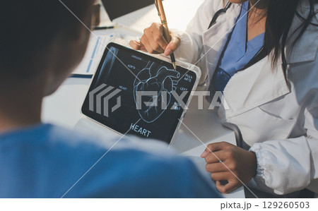 Cropped shot of an unrecognisable doctor sitting with his patient and showing her x-rays on a digital tablet Cropped shot of an unrecognisable doctor sitting with his patient and showing her x-rays on a digital tablet 129260503
