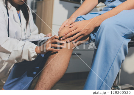 Physical therapist teaching a patient how to do exercises for his knee pain 129260520