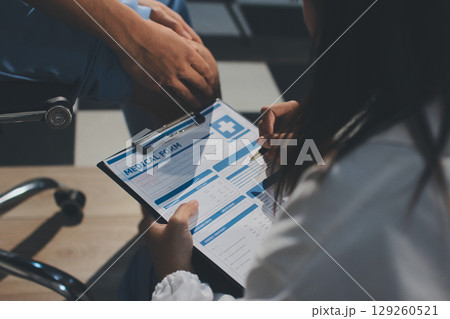 Physical therapist teaching a patient how to do exercises for his knee pain 129260521