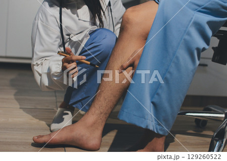 Physical therapist teaching a patient how to do exercises for his knee pain 129260522