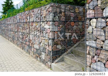 Modern Gabion Retaining Wall with Stone Fill and Concrete Staircase in Urban Landscape Design 129260653