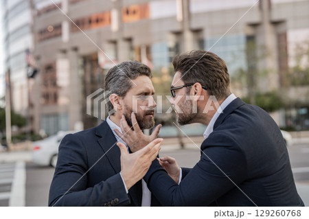 Angry businessmen. Business conflict. Two businessmen conflicting at fight outdoor. Businessmen having conflict in business. Conflict between boss and employee. Fight aggression. Blaming each other 129260768