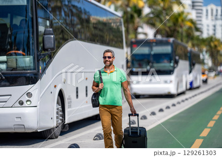 Travel lifestyle. Tourist in summer city. Travel bag. Summer trip in America. Mature tourist in Miami. Traveler man in casual clothes with suitcase. Man travel abroad weekend. Trip guide 129261303