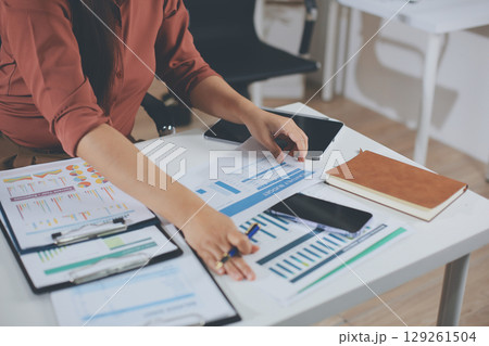 Portrait of young Hispanic professional business woman standing in office. Happy female company executive, smiling businesswoman entrepreneur corporate leader manager looking at camera using tablet 129261504