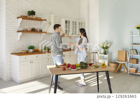 Happy Family Couple Dancing Together In The Kitchen While Cooking Food At Home Happy Family Couple Dancing Together In The Kitchen While Cooking Food At Home 129261663