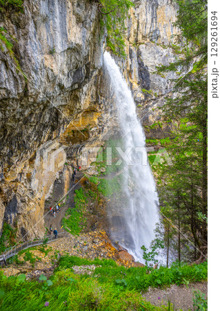 Visitors explore the breathtaking Johannes Waterfall surrounded by majestic cliffs in Obertauern, Austria. The clear water cascades down, creating a stunning natural spectacle. Visitors explore the breathtaking Johannes Waterfall surrounded by majestic cliffs in Obertauern, Austria. The clear water cascades down, creating a stunning natural spectacle. 129261694