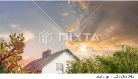 Eco-friendly home surrounded by nature with sustainable practices at sunset Eco-friendly home surrounded by nature with sustainable practices at sunset 129262048