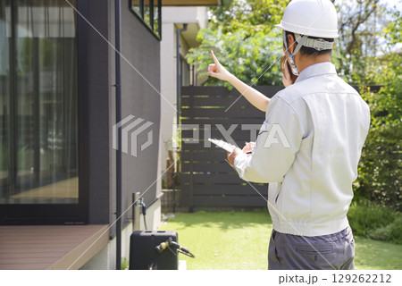 住宅の打ち合わせをする建築業者と女性 住宅の打ち合わせをする建築業者と女性 129262212