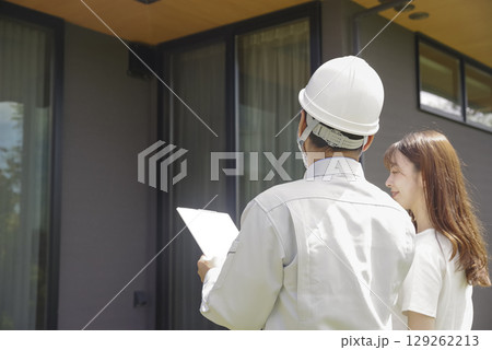 住宅の打ち合わせをする建築業者と女性 住宅の打ち合わせをする建築業者と女性 129262213