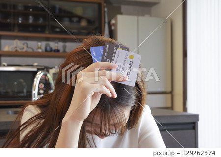 クレジットカードの支払いに悩む女性 クレジットカードの支払いに悩む女性 129262374