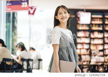 商業施設で立つ笑顔の若い女性 129262726