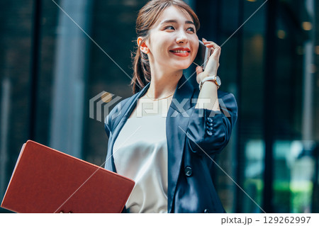 オフィスで電話をするスーツ姿の若いビジネスウーマン 129262997