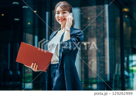 オフィスで電話をするスーツ姿の若いビジネスウーマン 129262999